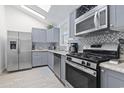 Modern kitchen with stainless steel appliances, gray cabinets, and sleek countertops, offering style and functionality at 113 Woodland Dr., Murrells Inlet, SC 29576