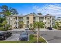 Well-maintained condo building with balconies, lush landscaping, and ample parking space at 144 Puffin Dr. # 3C, Pawleys Island, SC 29585