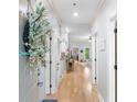 Bright hallway with hardwood floors leading to living spaces and a stylish decorative wreath at 144 Puffin Dr. # 3C, Pawleys Island, SC 29585
