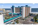 Expansive aerial view of the condo building near the ocean, showcasing its bridge and outdoor amenities at 1501 S Ocean Blvd. # 1231, Myrtle Beach, SC 29577