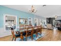 Elegant dining room featuring hardwood floors, a chandelier, and large windows providing plenty of natural light at 154 Sand Dollar St., Holden Beach, NC 28462