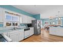 Bright kitchen with white cabinetry, stainless steel appliances, breakfast bar, and adjacent dining area at 154 Sand Dollar St., Holden Beach, NC 28462