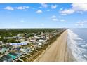 Sweeping aerial view of a coastal community with beachfront homes and direct beach access at 17 N Seaside Dr., Surfside Beach, SC 29575