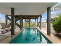 A private under-house pool with decorative fish tiles offers a refreshing escape at 17 N Seaside Dr., Surfside Beach, SC 29575