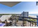 Balcony view of the ocean and resort-style neighborhood, including palm trees at 2001 S Ocean Blvd. # 914, Myrtle Beach, SC 29577