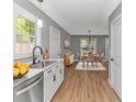 Well-lit kitchen with stainless steel appliances, white cabinets, and wood flooring at 23 Gabe Pl., Pawleys Island, SC 29585