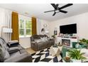 Inviting living room featuring a fireplace, large windows, a ceiling fan, and modern décor at 252 Legends Village Loop, Myrtle Beach, SC 29579