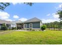 A spacious backyard with lush green grass, a screened porch, and a black iron fence at 2909 Moss Bridge Ln., Myrtle Beach, SC 29579