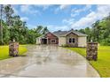 Wide shot of exterior showcasing the driveway leading up to a home with red siding and tan stonework at 3995 Tillmond Dr., Conway, SC 29526
