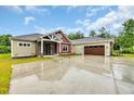 Exterior view of home showcasing red and tan siding, stylish stonework, and an attached two-car garage at 3995 Tillmond Dr., Conway, SC 29526