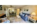Cozy living room featuring a blue sofa, coastal decor, and an open layout with views of the kitchen at 415 Ocean Creek Dr. # 2161, Myrtle Beach, SC 29572