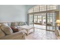 Comfortable living room with plush sofa, tile floors, and sliding glass doors to patio at 44 Hamby Dr., Pawleys Island, SC 29585
