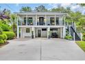 Two-story home featuring balconies and a covered parking area with a convenient golf cart at 476 Lakeshore Dr., Pawleys Island, SC 29585