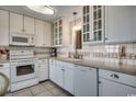 Bright kitchen features white cabinetry, modern appliances, tile backsplash, and ample counter space at 5905 S Kings Hwy. # 1717, Myrtle Beach, SC 29575
