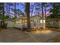 Charming single-story home with a cozy, illuminated porch set against a picturesque twilight sky at 6001-1501 S Kings Hwy., Myrtle Beach, SC 29575