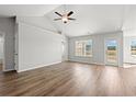 Open-concept living space with hardwood floors, ceiling fan, neutral paint, windows, and door for plenty of natural light at 610 Lightwood Dr., Conway, SC 29526
