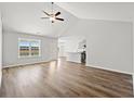Spacious living room with vaulted ceiling, hardwood floors, ceiling fan, and exterior views through large windows at 610 Lightwood Dr., Conway, SC 29526