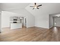 Open-concept living space with hardwood floors, vaulted ceilings, neutral paint, and seamless transition to the kitchen at 610 Lightwood Dr., Conway, SC 29526