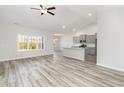 Spacious living room open to the kitchen featuring lots of natural light and modern wood flooring at 618 Lightwood Dr., Conway, SC 29526