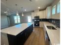 Contemporary kitchen boasting a central island, pendant lighting, and stainless steel appliances at 753 Wailea Circle, Little River, SC 29566
