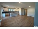 Open-concept living space highlighting a spacious kitchen with an island and wood-look flooring at 753 Wailea Circle, Little River, SC 29566