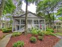Two-story condo features double balconies and is surrounded by mature trees and manicured landscaping at 75-4 Weehawka Way # 4, Pawleys Island, SC 29585