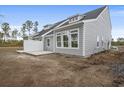 New construction home with a patio area and large windows, set in an undeveloped yard at 8803 Reya Rd # 163B, Longs, SC 29568