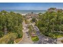 Stunning clubhouse overlooking the ocean is nestled among lush trees, with a welcoming driveway at 9485 Ronda Ct., Myrtle Beach, SC 29579