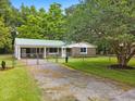 Quaint single-story home with a green metal roof, stone accents, fenced yard and covered parking at 96 Middleton Rd., Andrews, SC 29510