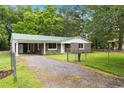 Single-story home boasting stone facade, a green metal roof, an attached carport and fenced in yard at 96 Middleton Rd., Andrews, SC 29510