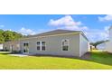 View of the back exterior of the home, showing the siding, yard, and sliding glass doors at 1004 Sentinel Ct., Little River, SC 29566