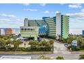 An exterior daytime view of the Coral Beach Resort and surrounding palm trees, parking, and ocean at 1105 S Ocean Blvd. # 724, Myrtle Beach, SC 29577