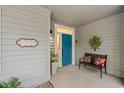 Inviting front porch with a bright blue door, a 'Welcome' sign, bench seating, and stylish decorations at 1221 Tidewater Dr. # 2811, North Myrtle Beach, SC 29582