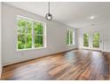 Bright living room features hardwood floors, neutral paint, large windows with view, and patio doors at 144 Puffin Dr. # 2A, Pawleys Island, SC 29585