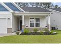 Inviting front porch with brick accents, manicured landscaping, and a charming entryway at 2405 Capri Court, Conway, SC 29527