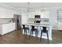 Modern kitchen featuring stainless steel appliances, white cabinets, and a kitchen island with barstool seating at 2429 Watershed Way, Longs, SC 29568