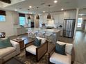 Open-concept kitchen with large island, stainless steel appliances, pendant lighting, and hardwood floors at 2521 Watershed Way, Longs, SC 29568