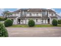 Neat townhouse complex with gray siding and well-maintained front entrances with white doors and windows at 3700 Golf Colony Lane # 6J, Little River, SC 29566
