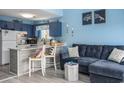 Cozy living space with blue walls, a sectional sofa, and an open kitchen with a breakfast bar at 3700 Golf Colony Lane # 6J, Little River, SC 29566