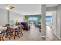 Open-concept living room with tile floors, a dining area, and ocean views through bright windows at 5806 N Ocean Blvd. # 203, North Myrtle Beach, SC 29582