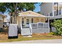 Charming yellow cottage with a welcoming front porch, string lights, and a cozy beach vibe at 6001 - 1820A S Kings Hwy., Myrtle Beach, SC 29575