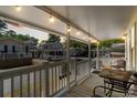 Inviting covered porch with string lights, a metal table and seating, perfect for relaxing at 6001 - 1820A S Kings Hwy., Myrtle Beach, SC 29575