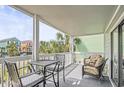 Screened balcony features table and chairs with patterned pillows with a view of the neighborhood at 612 N Ocean Blvd. # 103, Surfside Beach, SC 29575