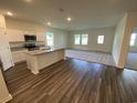 Open-concept kitchen with island, granite countertops, stainless appliances, and hardwood floors at 620 Muster Field Ct., Conway, SC 29526