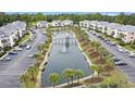 Aerial view of condos surrounding a scenic pond with fountain and bridge, lined with palm trees at 637 Waterway Village Blvd. # 13C, Myrtle Beach, SC 29579