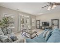 Bright living room with a neutral palette, tile floors, and ample natural light from large windows and doors at 703 37Th Ave. S, North Myrtle Beach, SC 29582