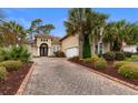 Charming home featuring mature landscaping and a paved driveway leading to the garage and front entrance at 7253 Seville Dr., Myrtle Beach, SC 29572