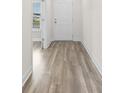 Hallway view features light wood floors, white trim, and a white entry door at 739 Harrison Mill St., Myrtle Beach, SC 29579