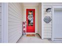 Charming front entrance with a vibrant red door, a welcoming mat and stylish decor at 1009 Oak Marsh Ln., North Myrtle Beach, SC 29582