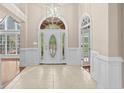 Elegant foyer with decorative front door, arched transom window, and paneled walls at 1315 Cherry Dr., Surfside Beach, SC 29575